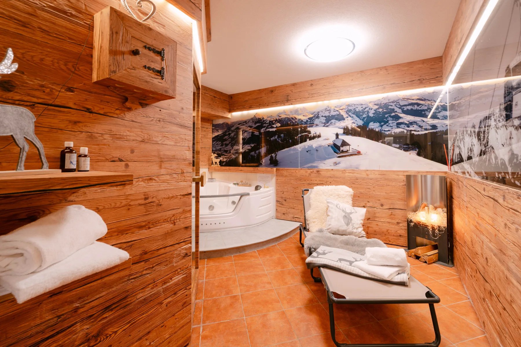 Un spa revestido de madera cuenta con una bañera de hidromasaje, asientos y una chimenea.