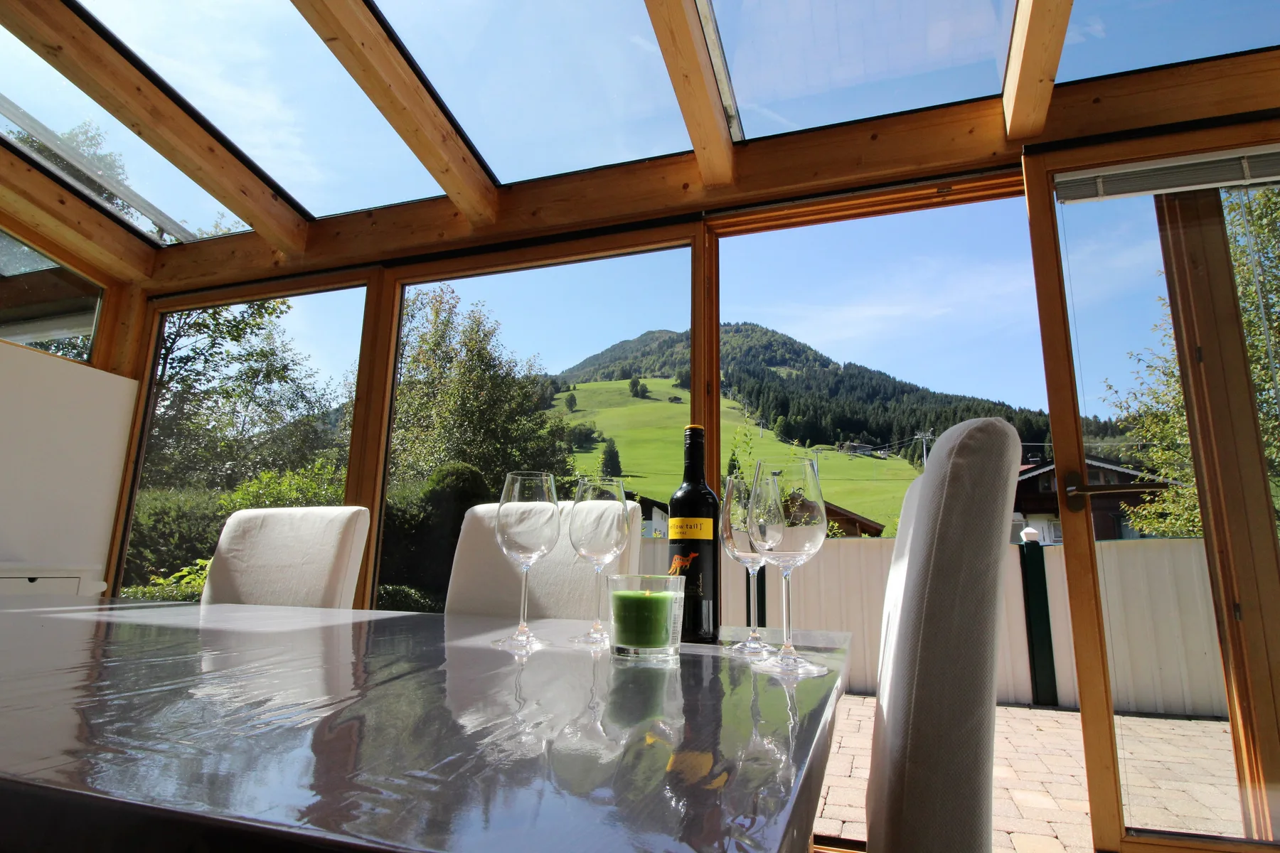 Un comedor acristalado ofrece vistas a una ladera verde.