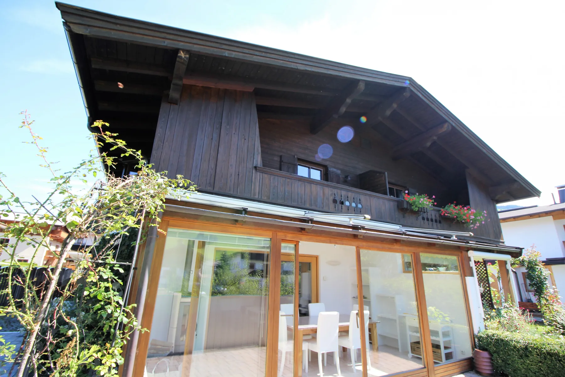 Una casa de madera con amplias puertas de vidrio que dan a un patio.