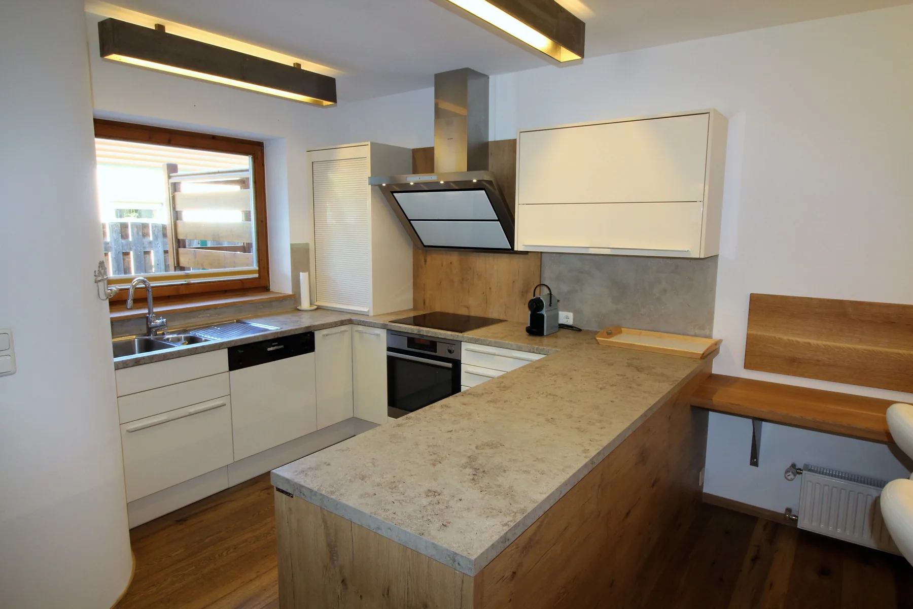 Una cocina moderna con una isla central, armarios y un fregadero bajo la ventana.