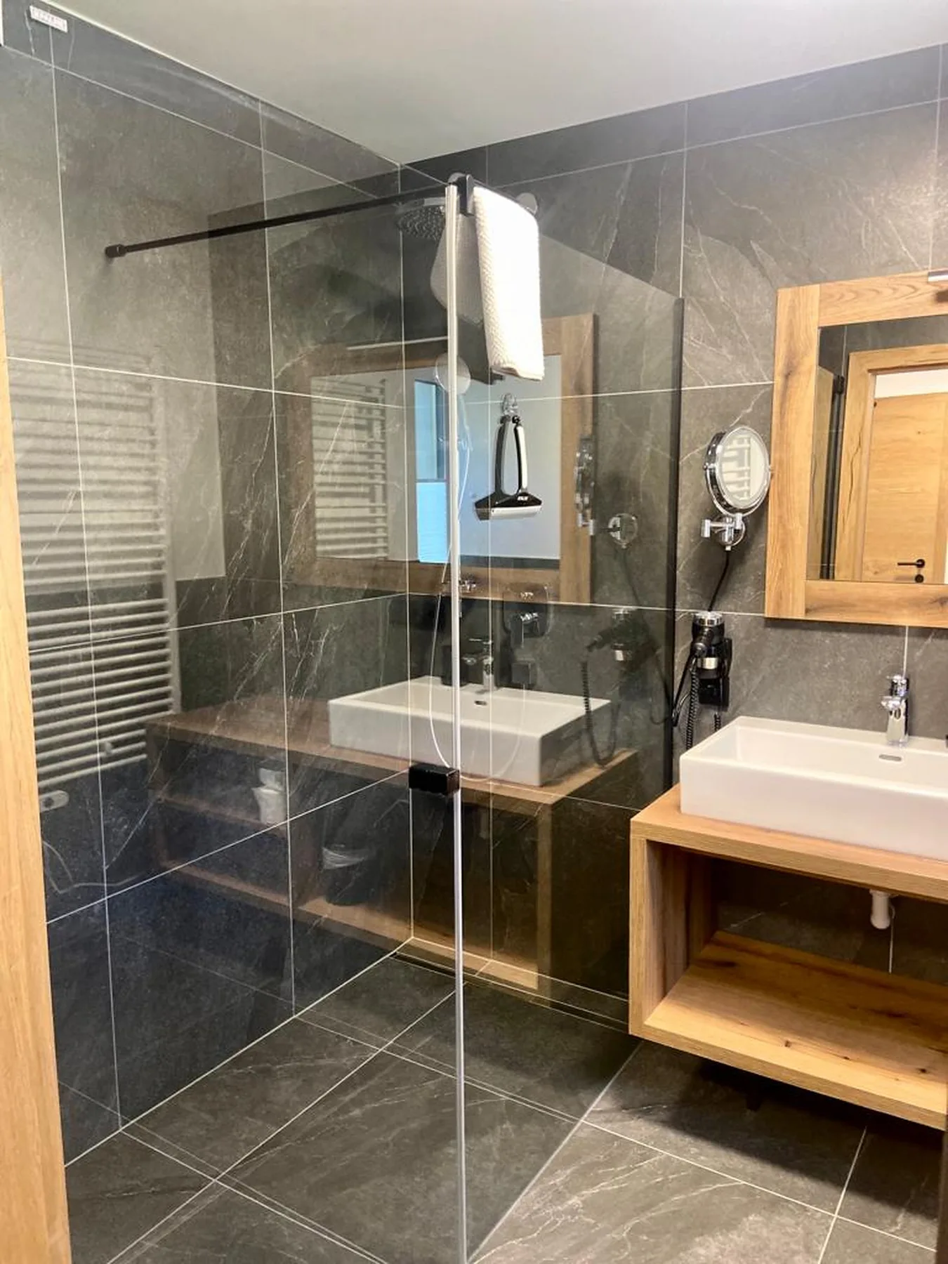 A tiled bathroom with a glass shower and a sink vanity.
