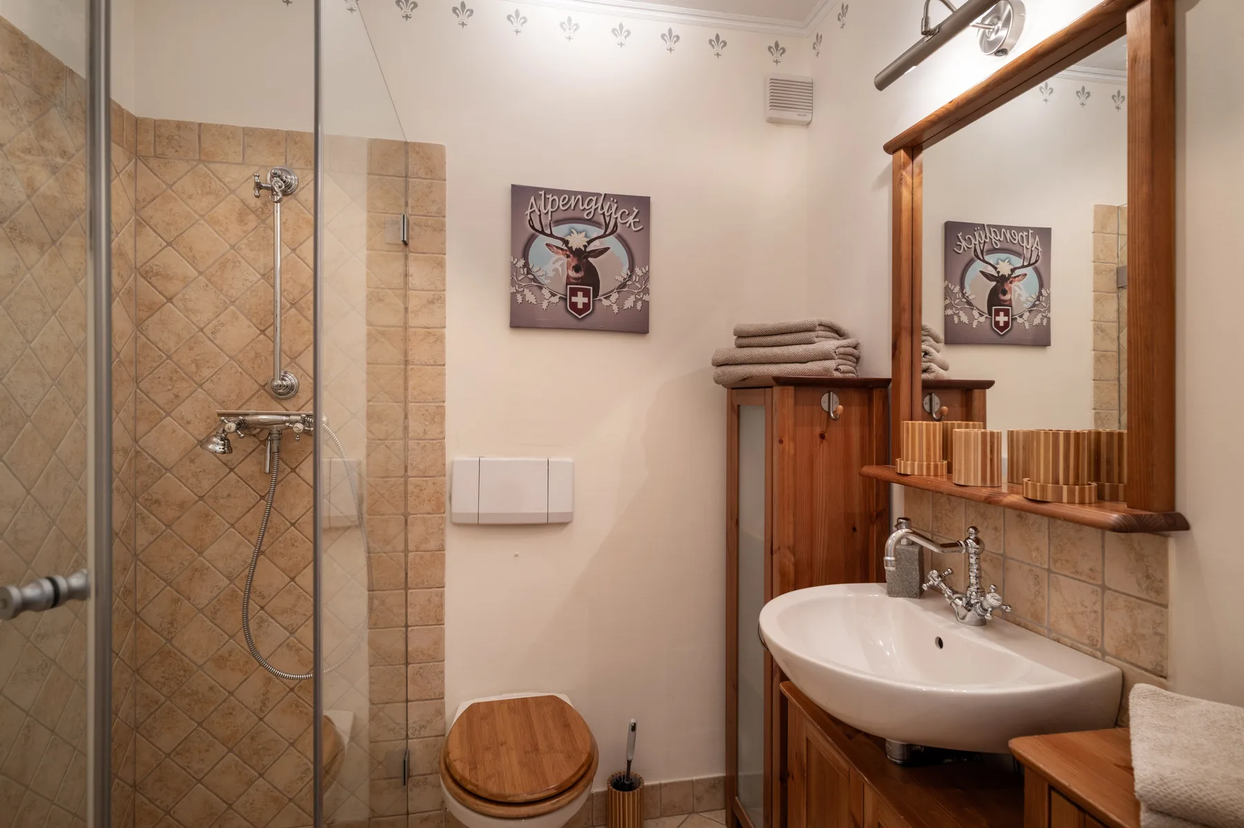 Un baño con ducha de vidrio, lavabo y tocador de madera.