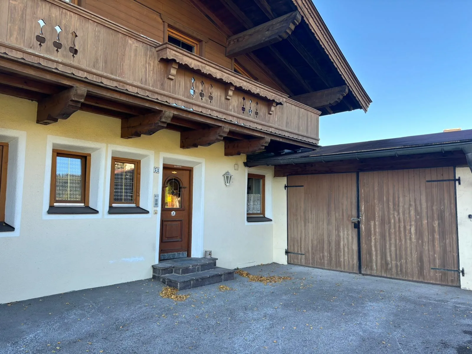 Zona común: La entrada de una casa junto a una puerta de garaje de madera.