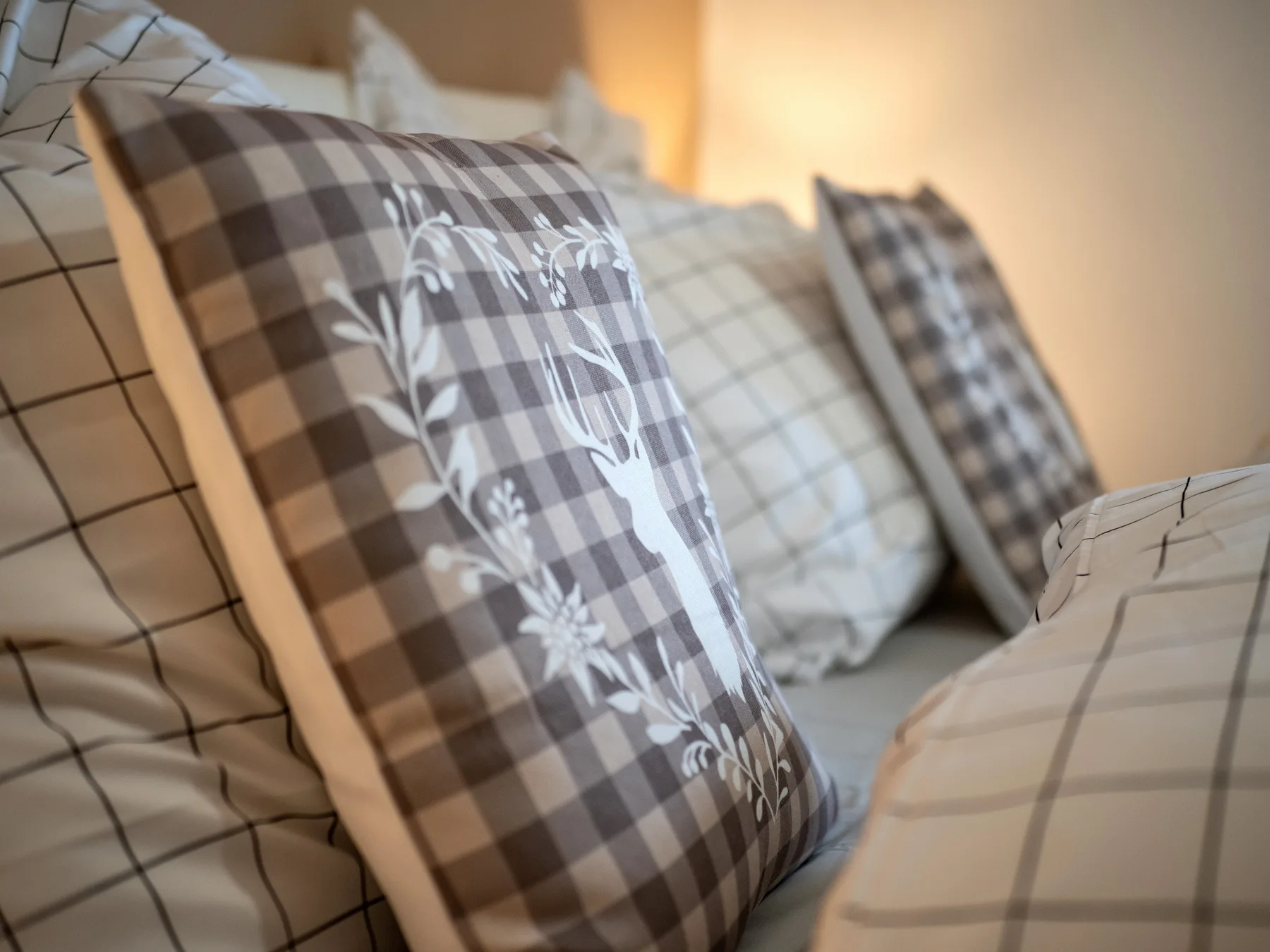 Un dormitorio con almohadas estampadas dispuestas sobre una cama.