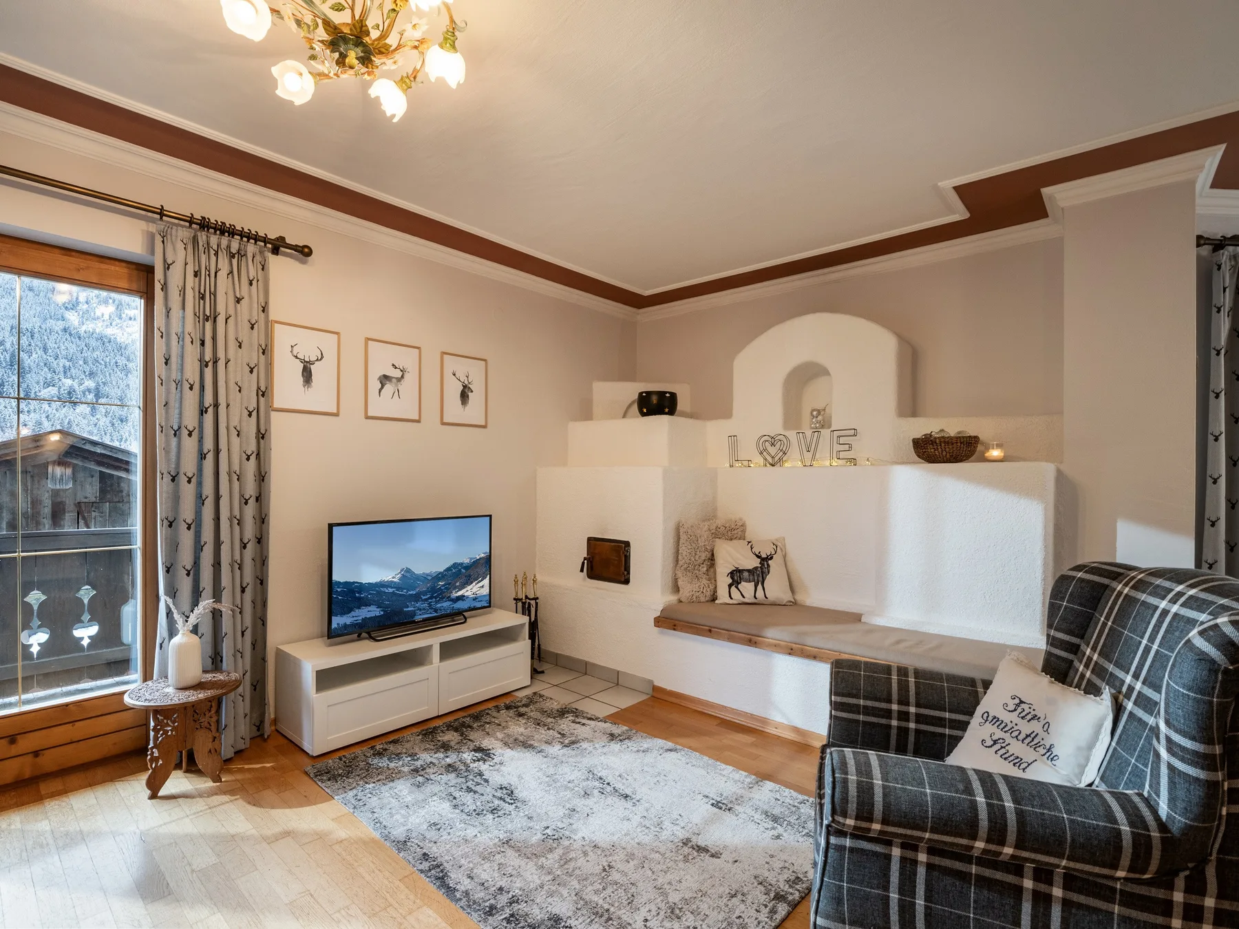 Una sala de estar con televisor, asientos y chimenea.