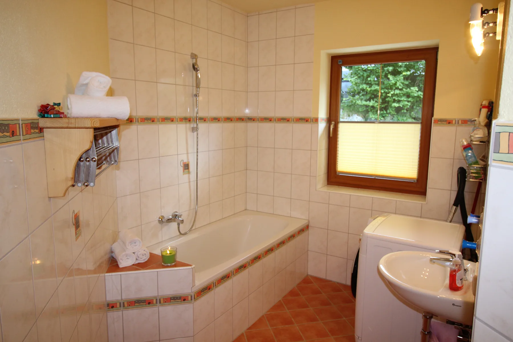A tiled bathroom with a bathtub, sink, and window.