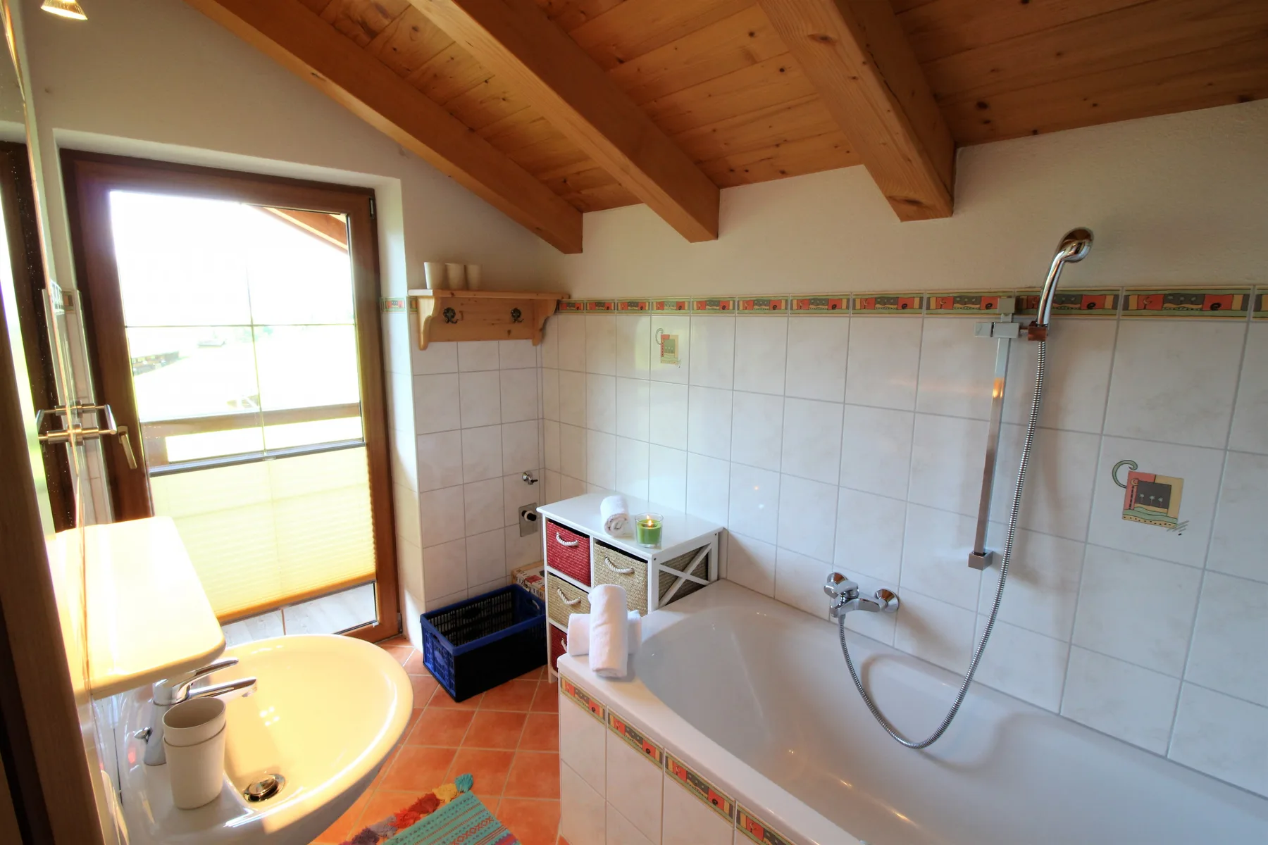 A tiled bathroom with a bathtub, sink, and large window.
