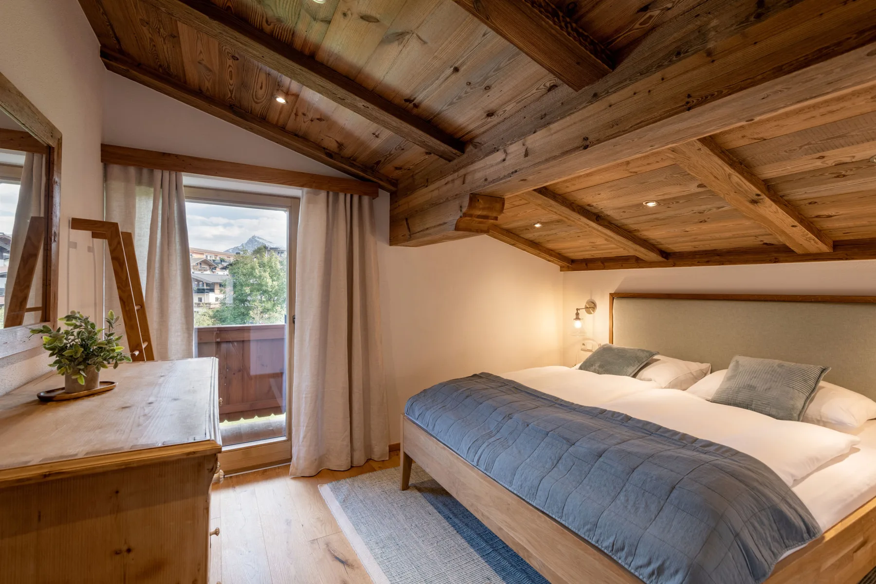 Un dormitorio con una cama grande bajo un techo inclinado de madera.