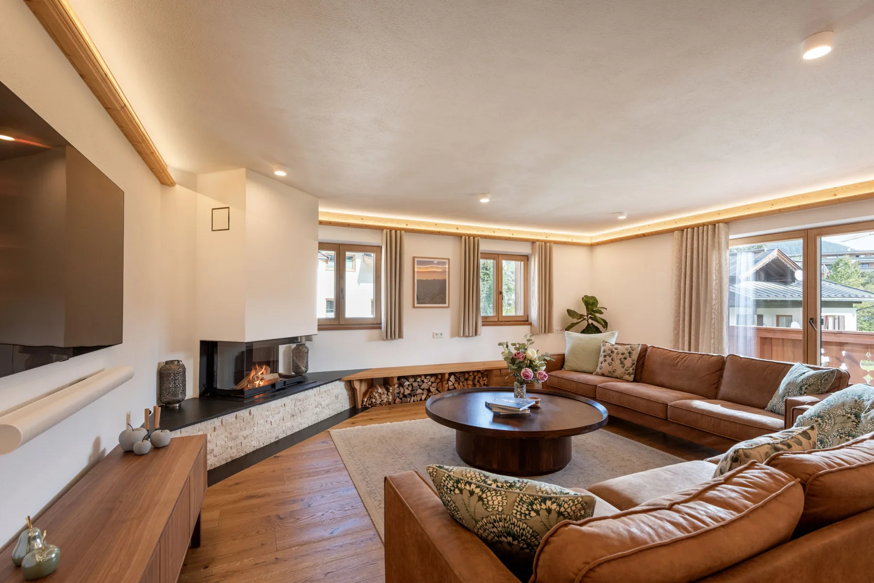 Una sala de estar luminosa con asientos alrededor de una mesa baja y una chimenea.
