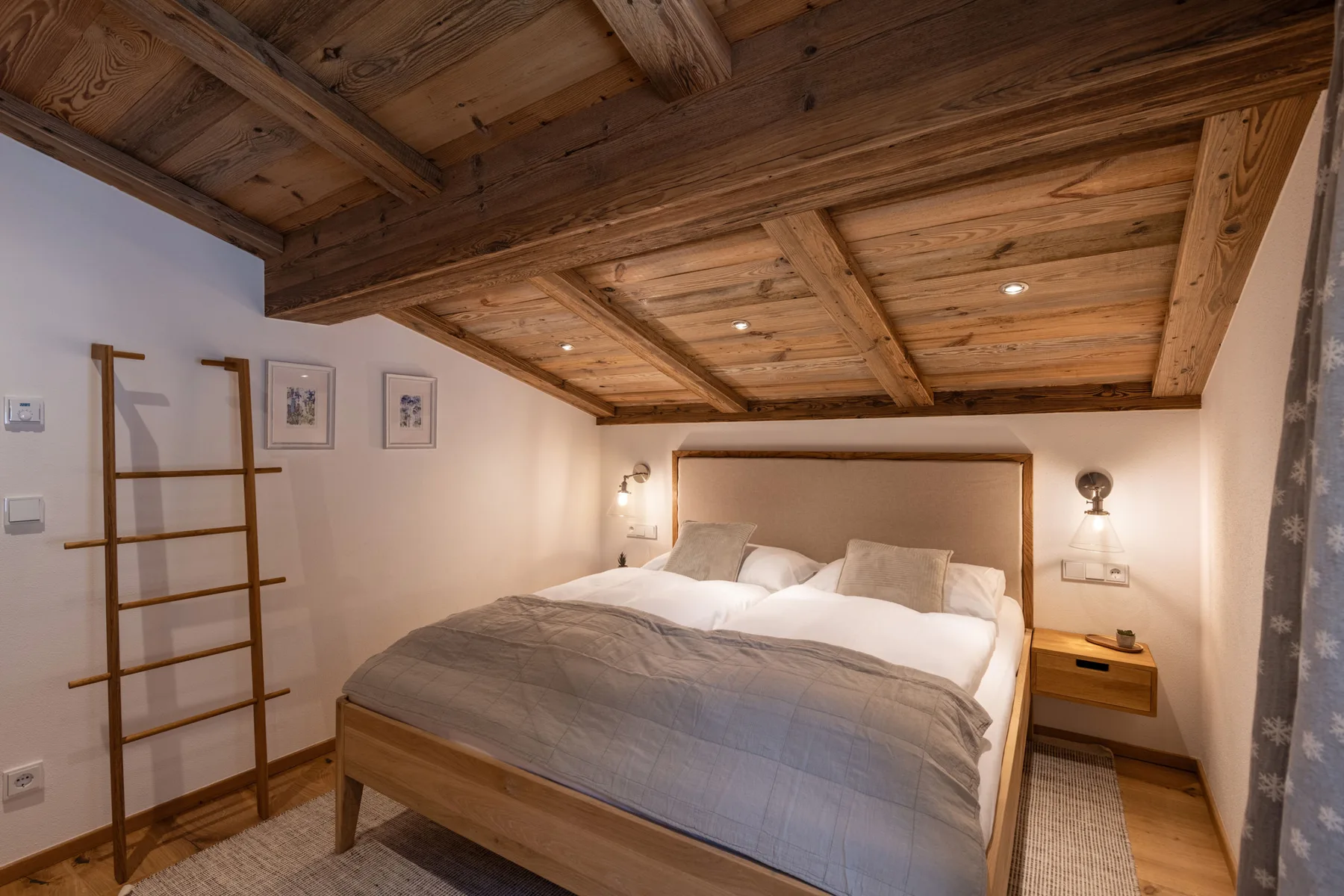 Un dormitorio con una cama bajo un llamativo techo de madera vista.