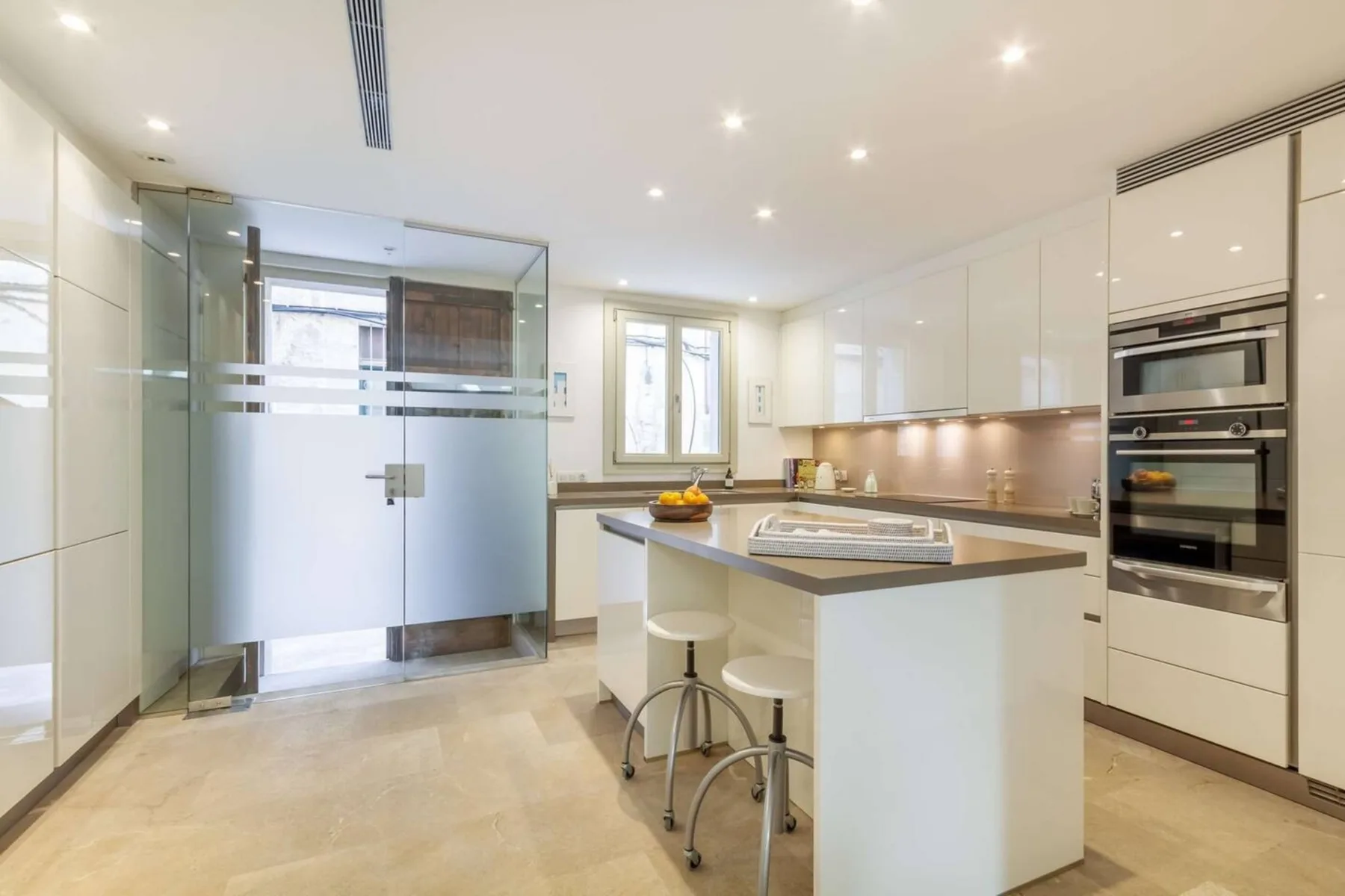 Una cocina moderna y luminosa con una isla central y electrodomésticos integrados.