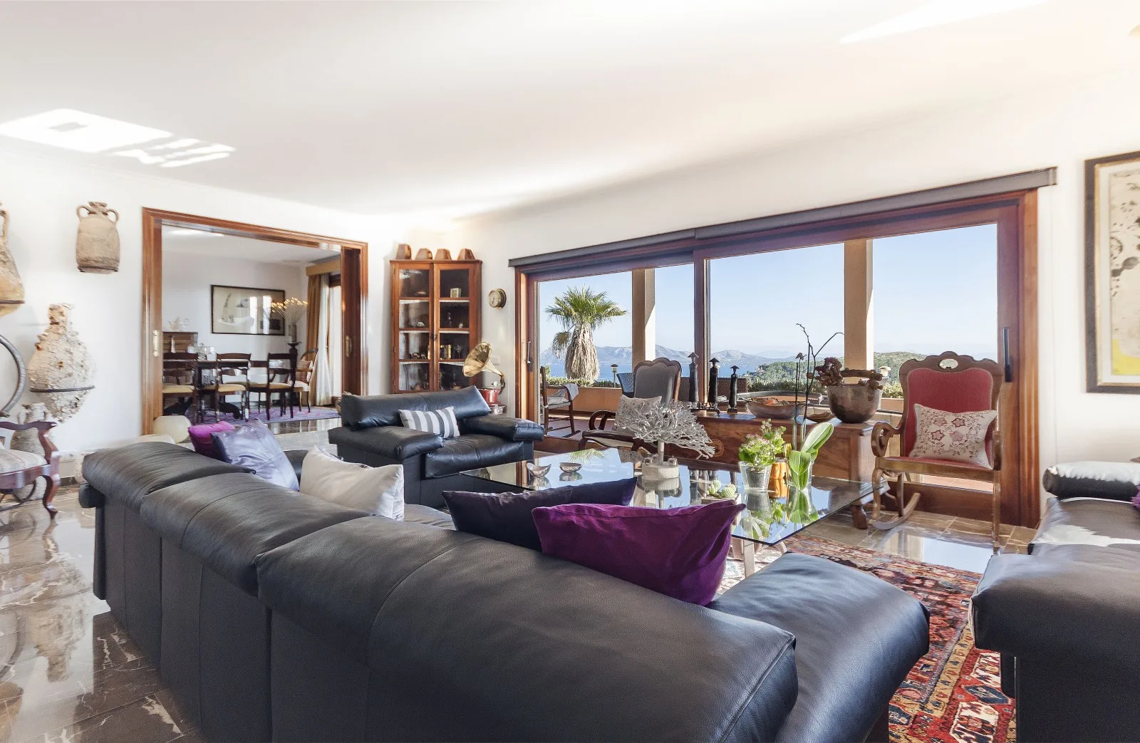 A bright living room with seating arranged around a glass coffee table.