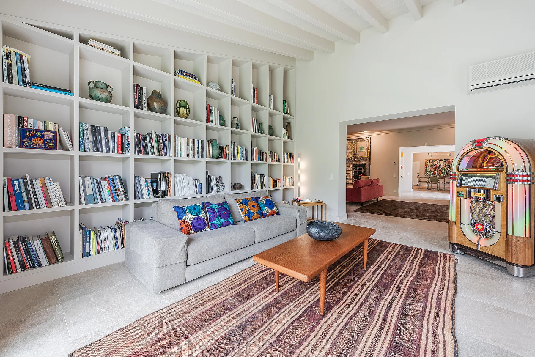 A living room with a sofa, bookshelves, and a wooden coffee table.