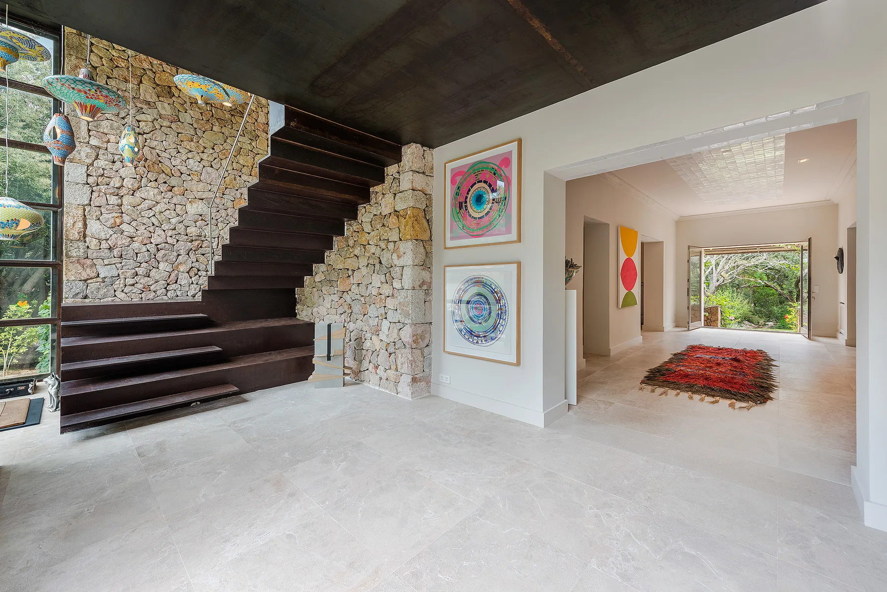 A stone-walled entry hall features a dark staircase beside an open passage.