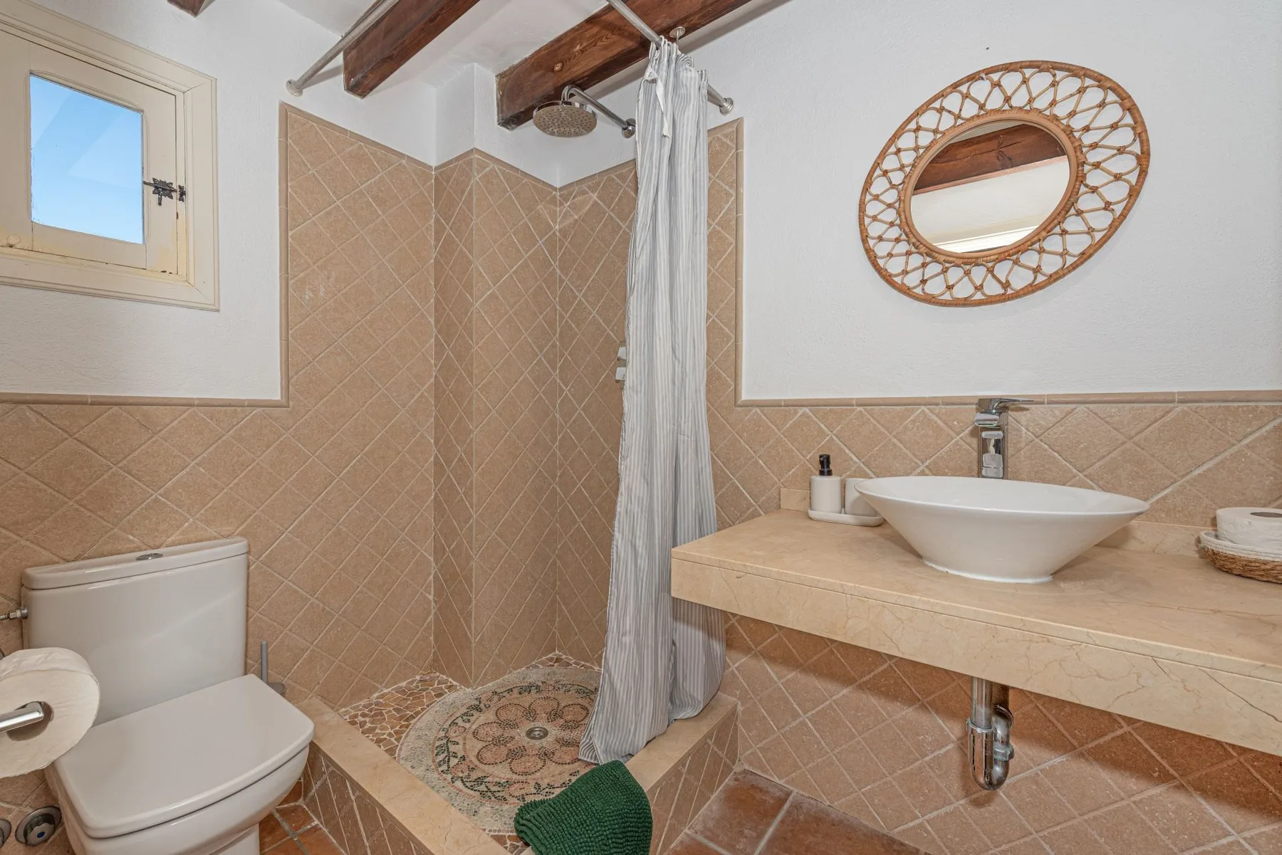 Un baño con azulejos, ducha, lavabo e inodoro.