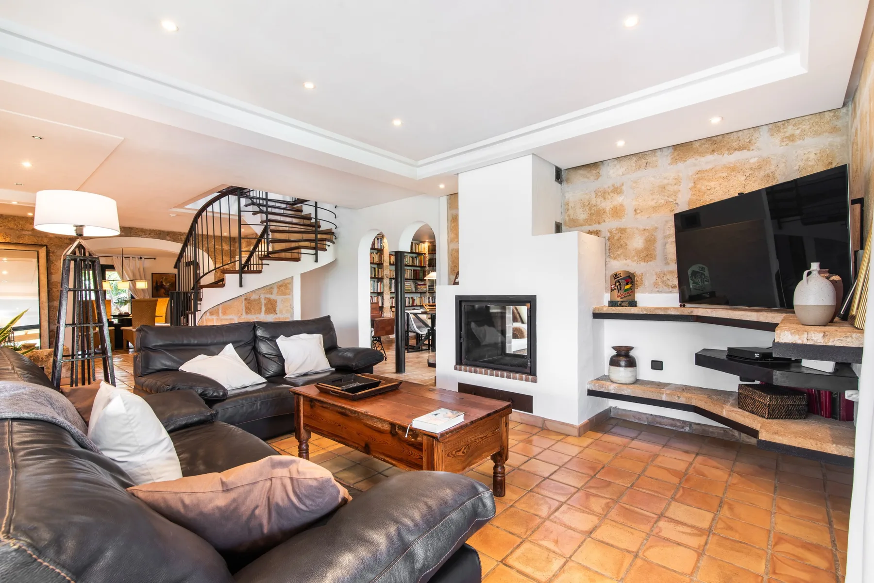 A living room with seating, a fireplace, and a television.