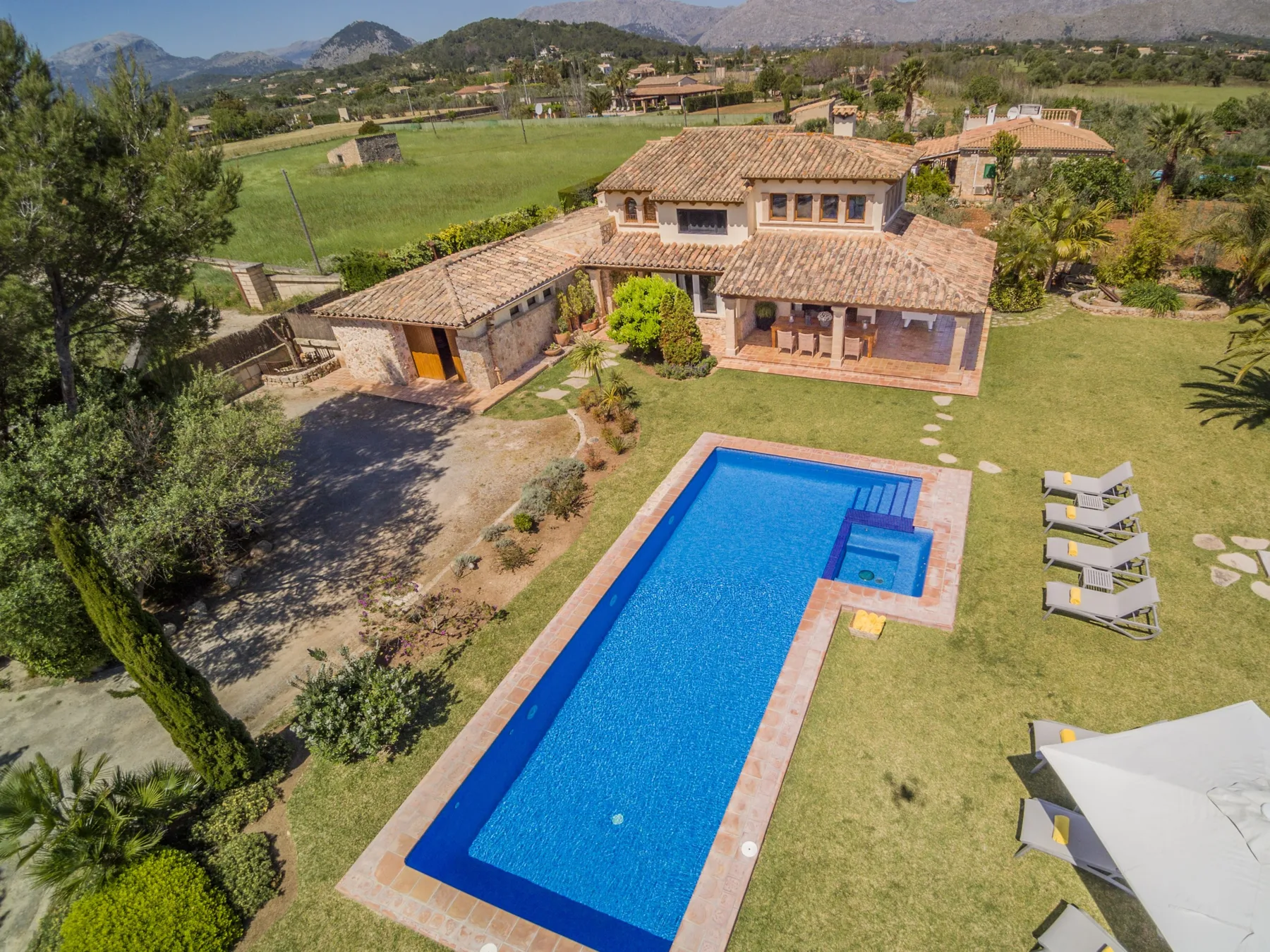 A countryside property with a swimming pool and tiled-roof buildings.