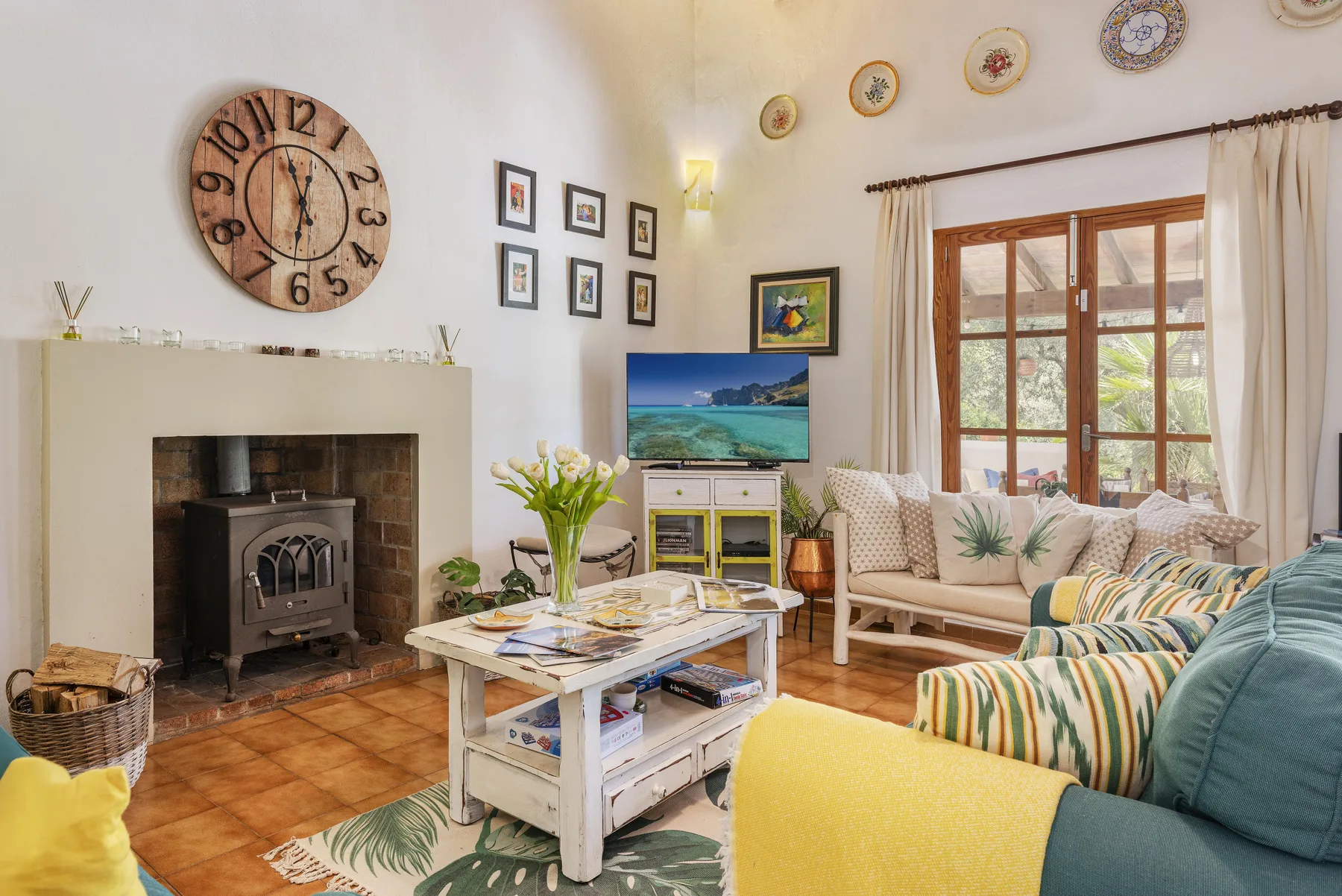 Una sala luminosa con chimenea, asientos y una mesa de centro baja.