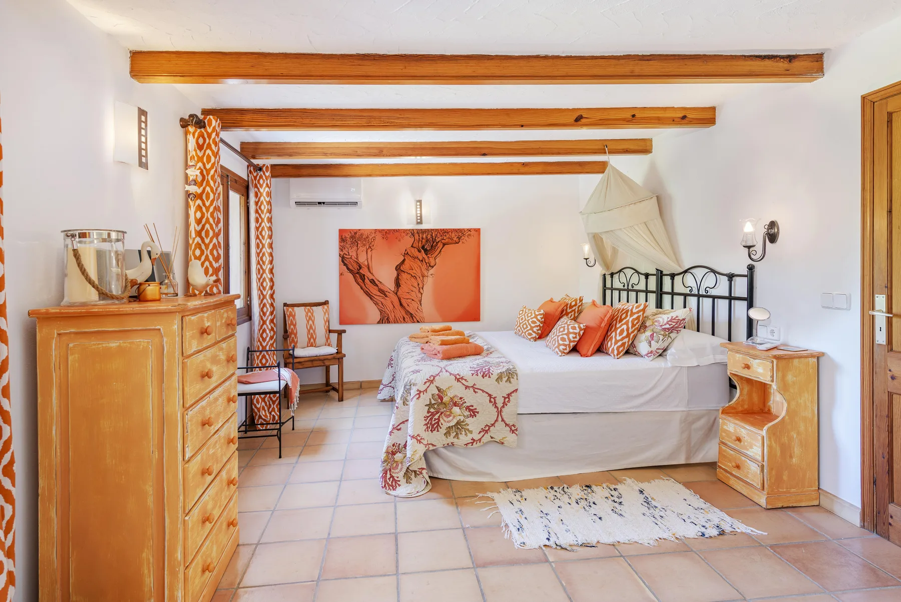 Dormitorio con una cama, muebles de madera y vigas expuestas en el techo.
