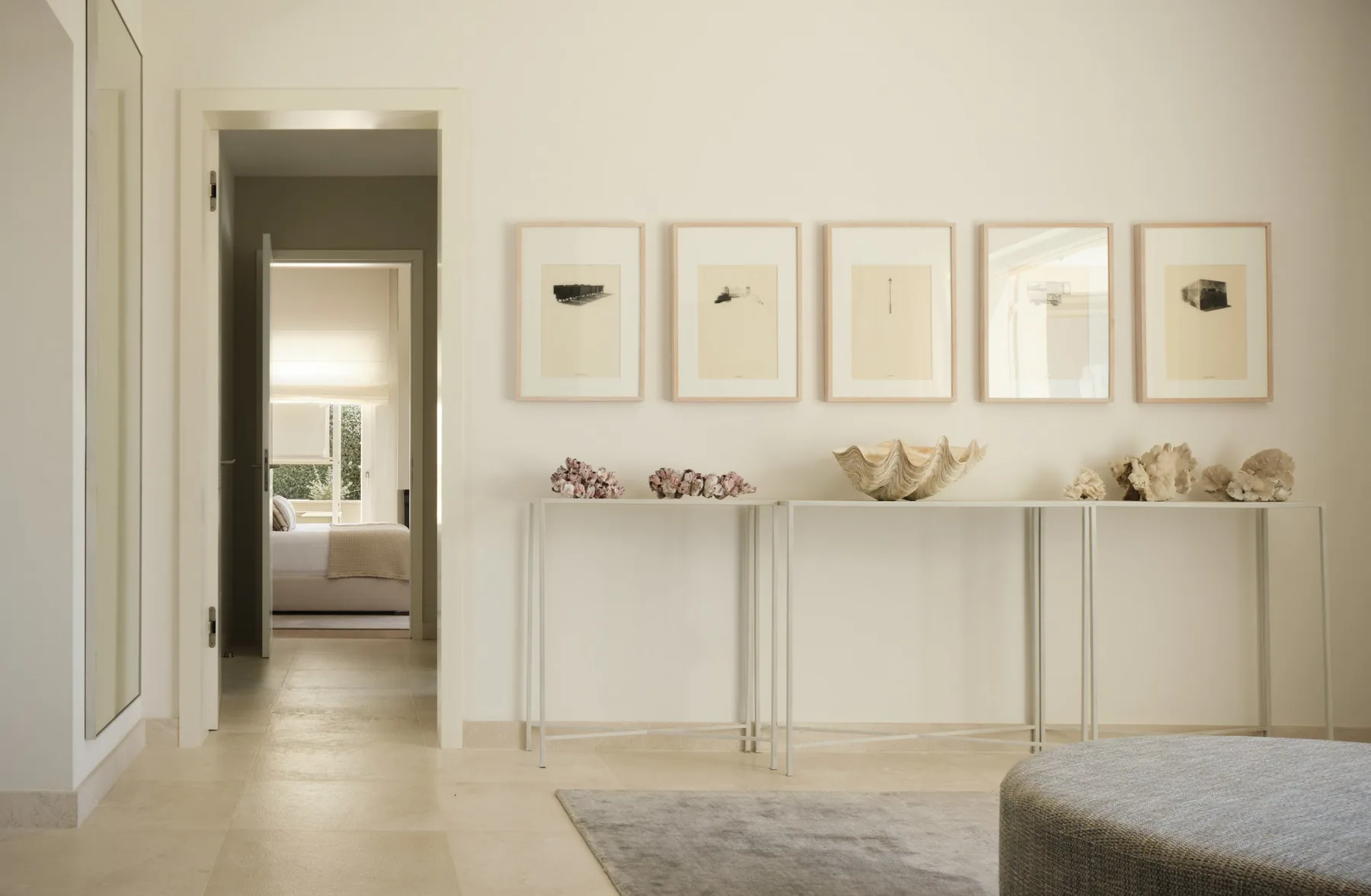 A bright interior hallway with framed artwork and a console table.