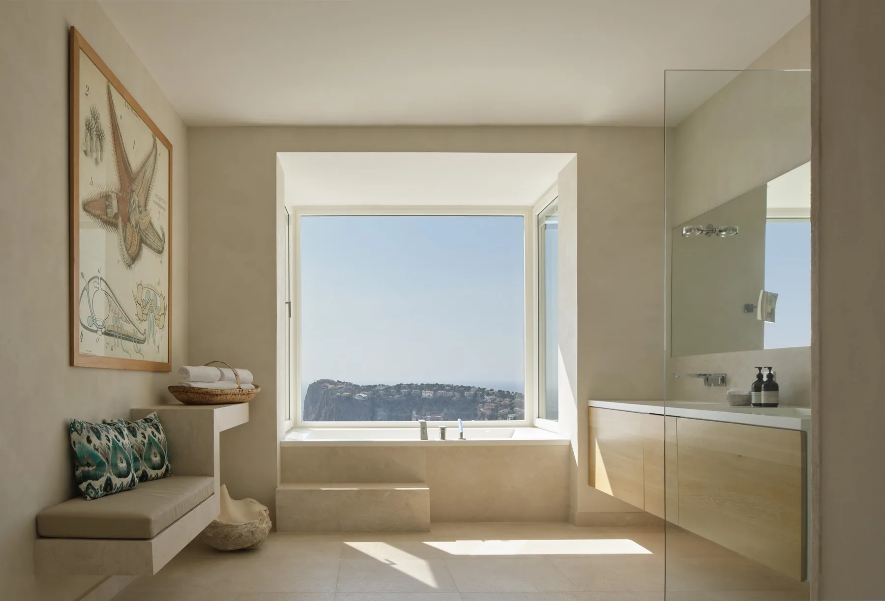 A bright bathroom features a large window overlooking a distant landscape.