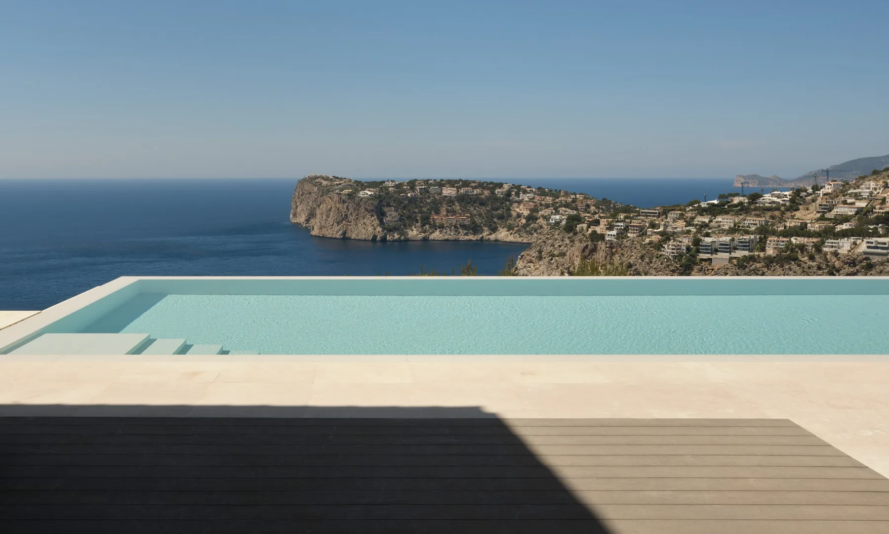 Infinity pool overlooking the sea and a rocky coastline.