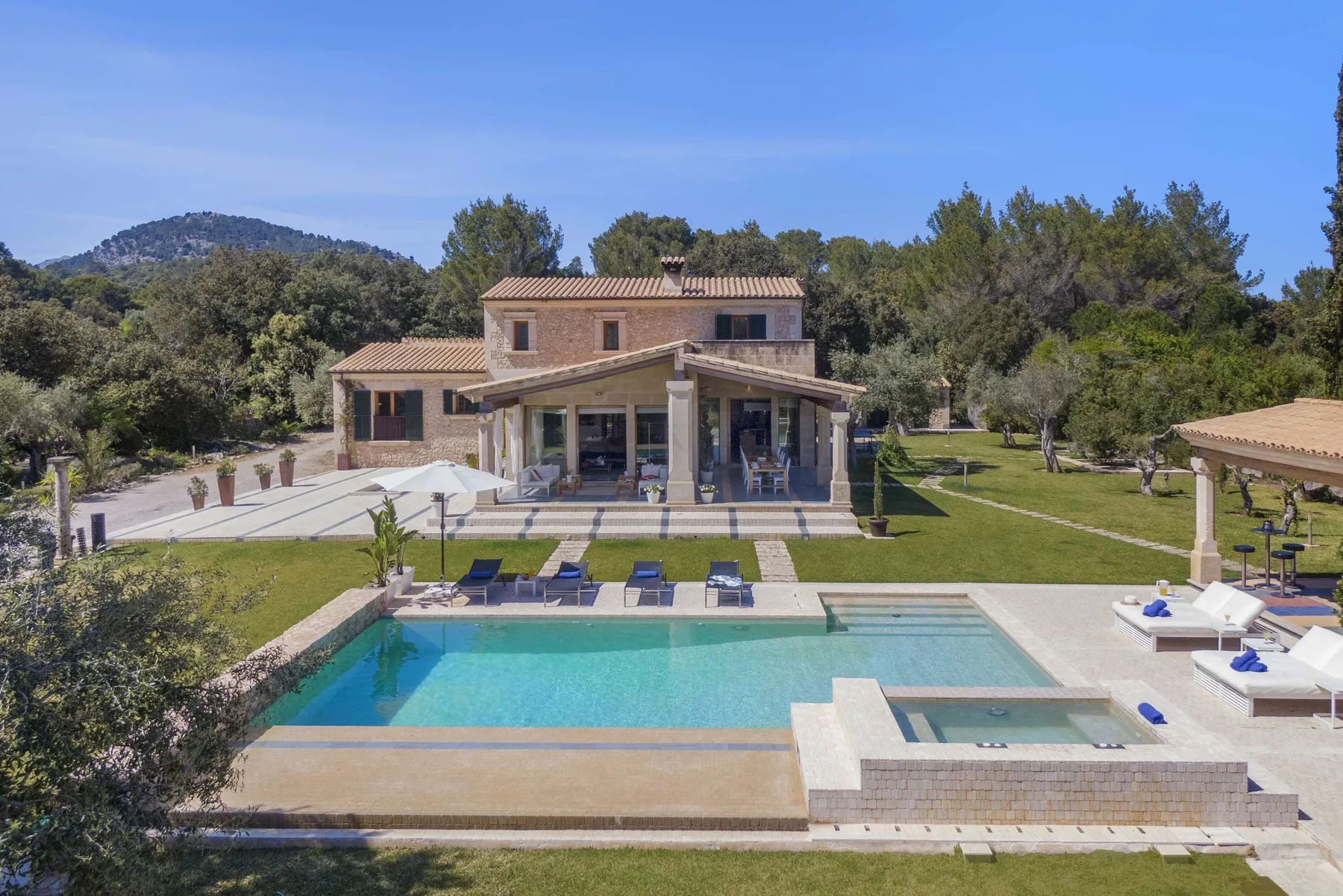 A villa and landscaped grounds with a swimming pool in the foreground.