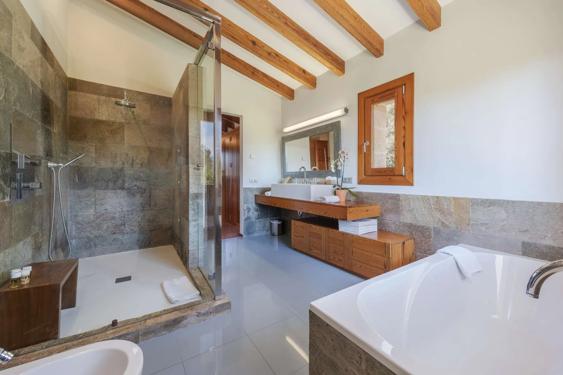 A spacious bathroom with a glass shower, double vanity, and freestanding bathtub.