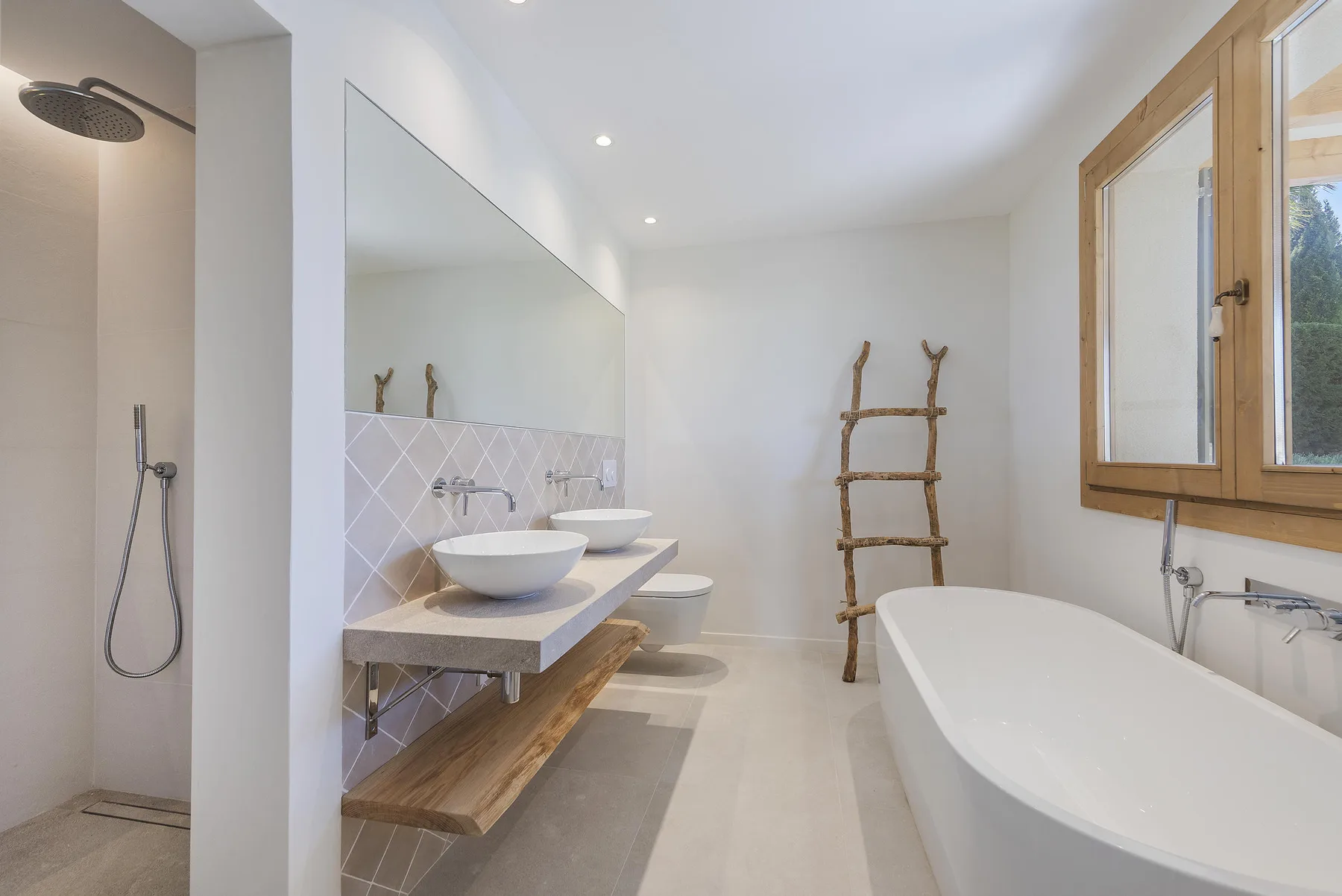 A bright bathroom with a bathtub, walk-in shower, and double sinks.