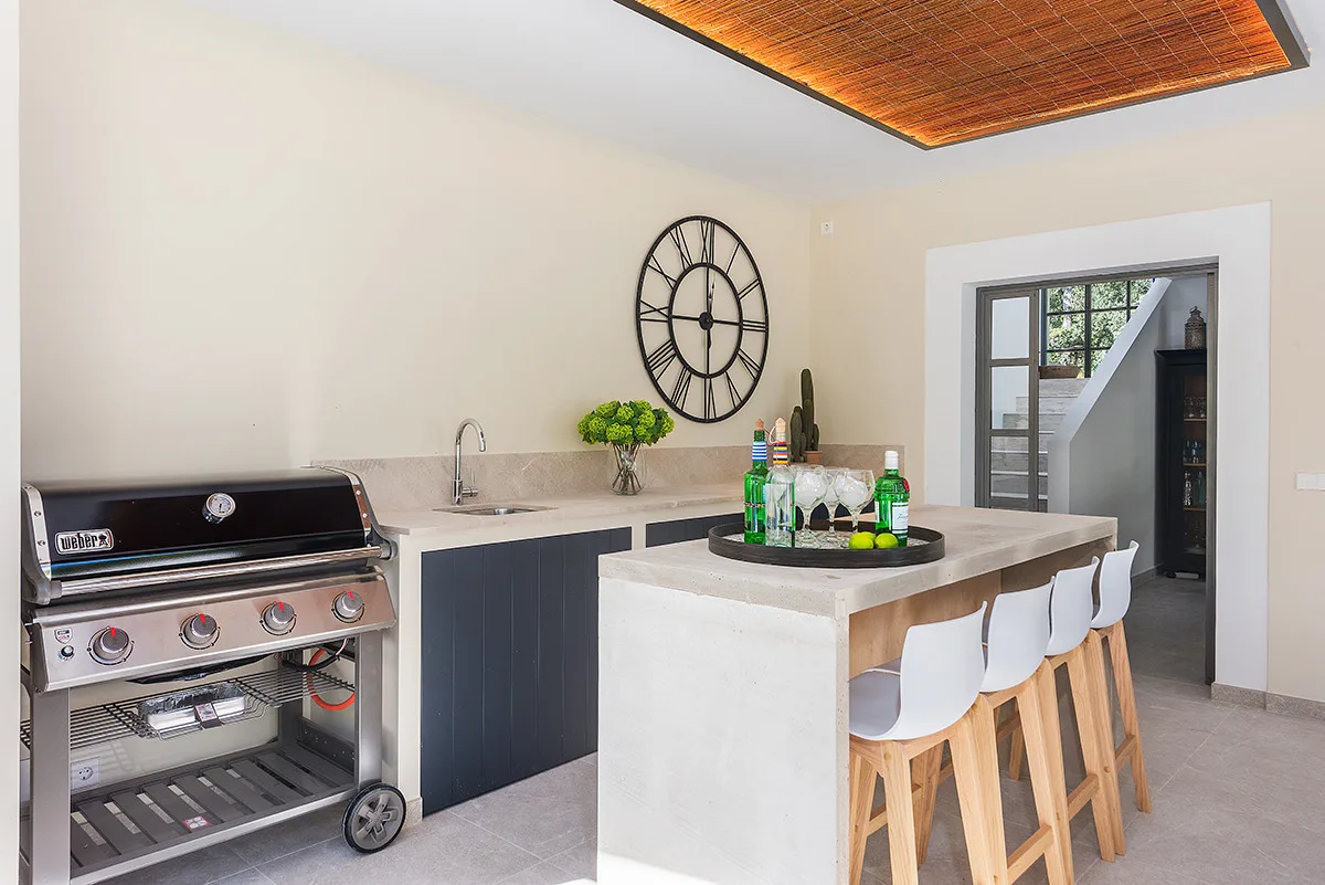 An indoor kitchen and bar area with a grill, counter, and seating.
