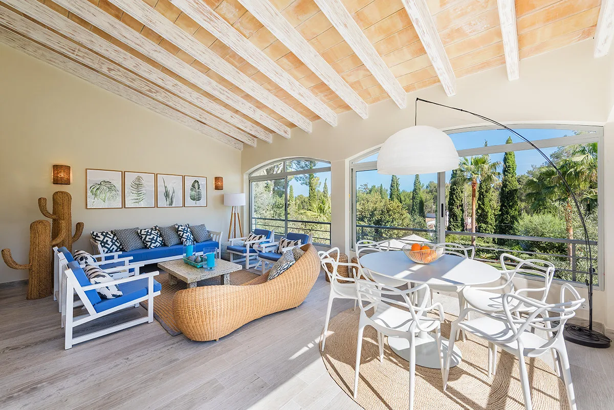 A bright living and dining area opens onto a terrace with garden views.