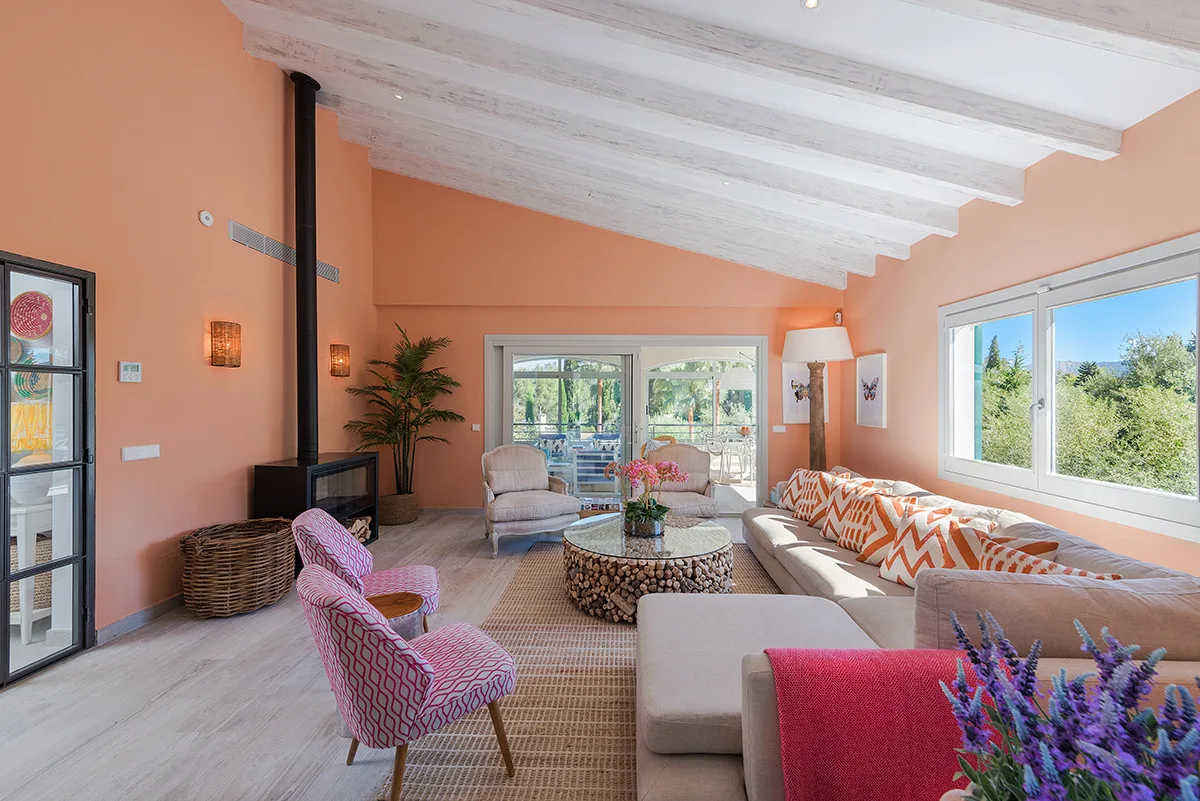 A bright living room with seating, a coffee table, and large windows.