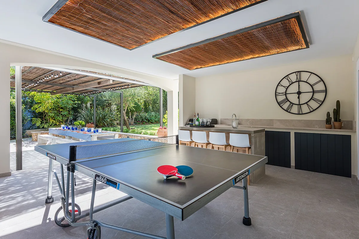A recreation room with a ping-pong table and a counter along the wall.