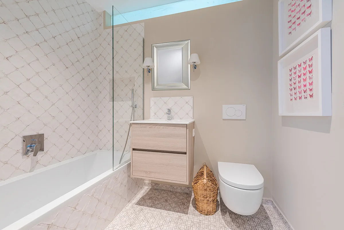 A bathroom with a bathtub, vanity, and toilet.