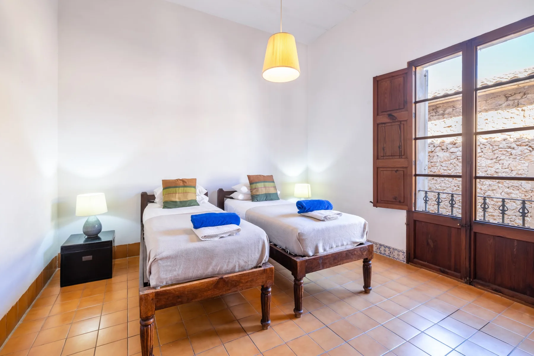 Un dormitorio luminoso con dos camas y una ventana grande.