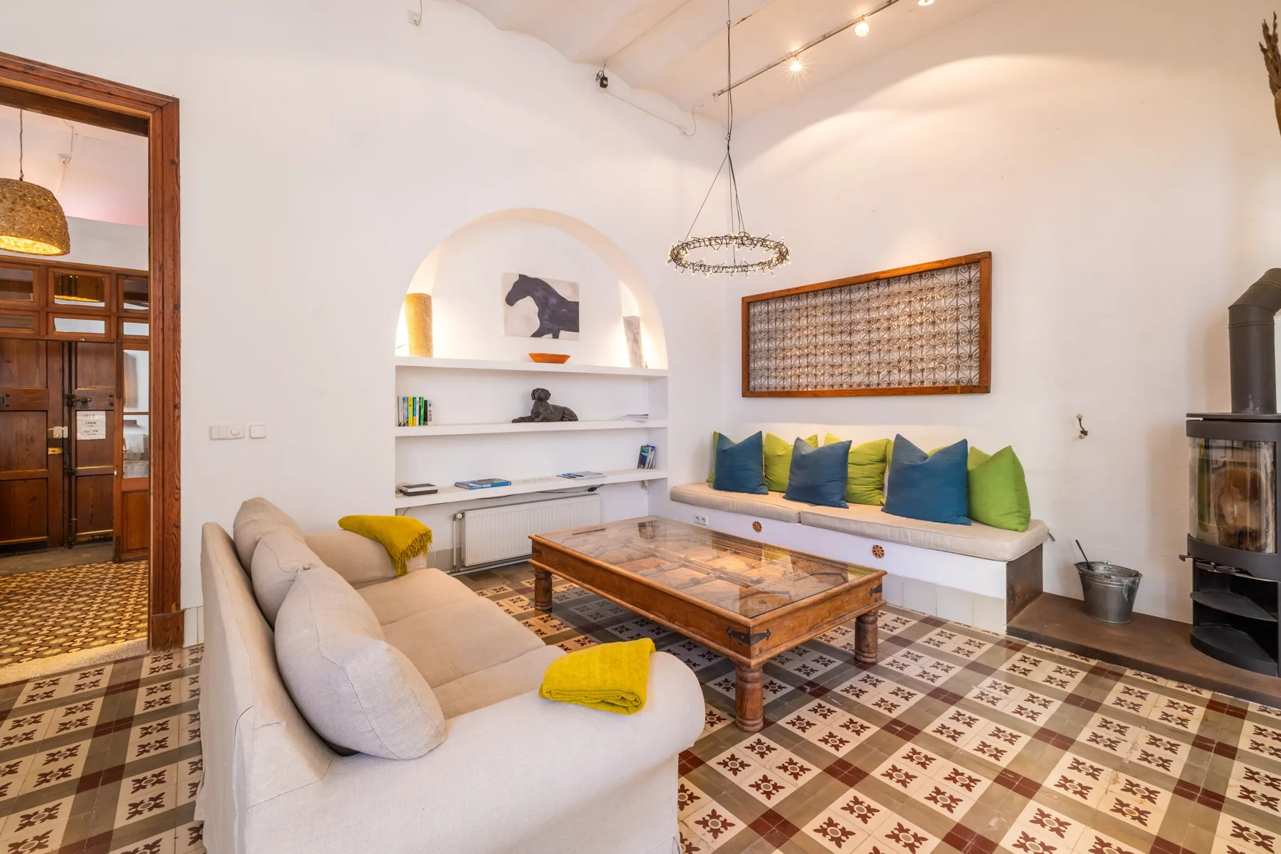 Una sala luminosa con estantes empotrados y un banco largo acolchado.