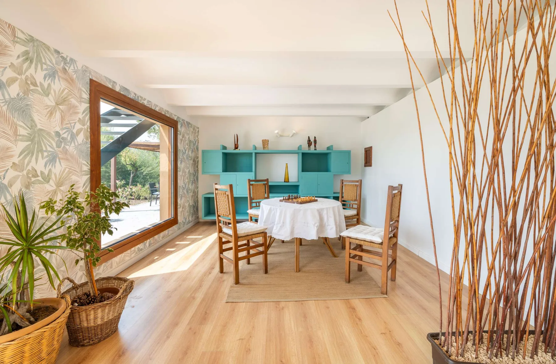 A dining area with a table, chairs, and turquoise shelving.