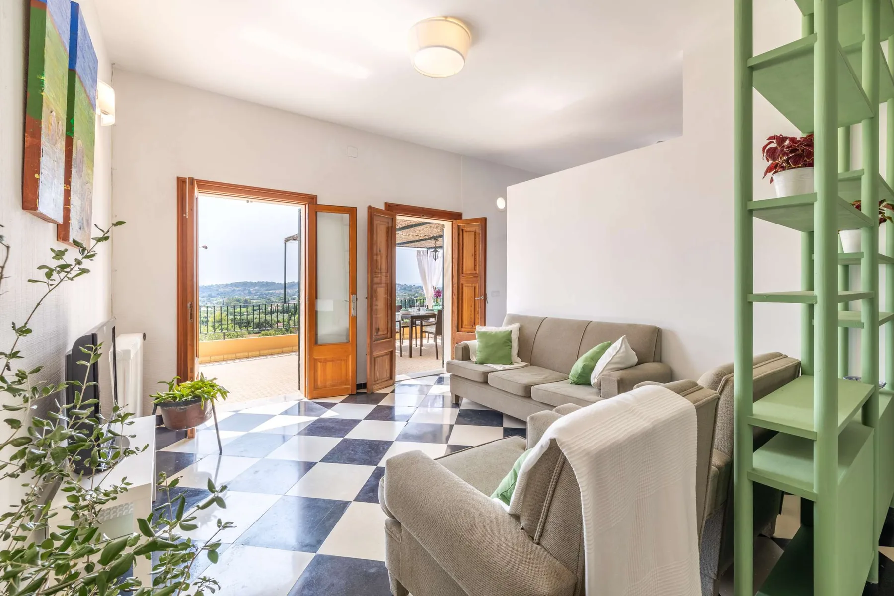 A bright living room with seating and open doors leading to a balcony.