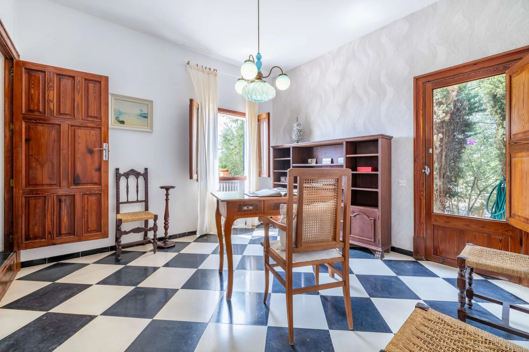 A dining area with wooden seating, a cabinet, and large windows.