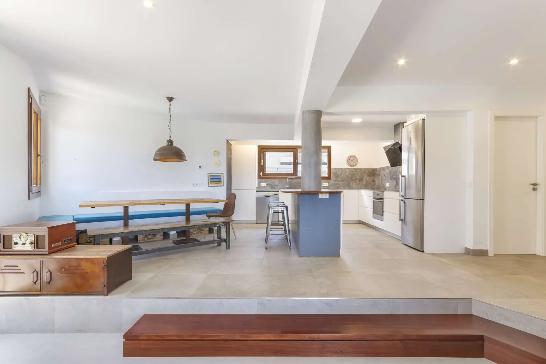 An open-plan kitchen and dining area with a long built-in bench and central island.