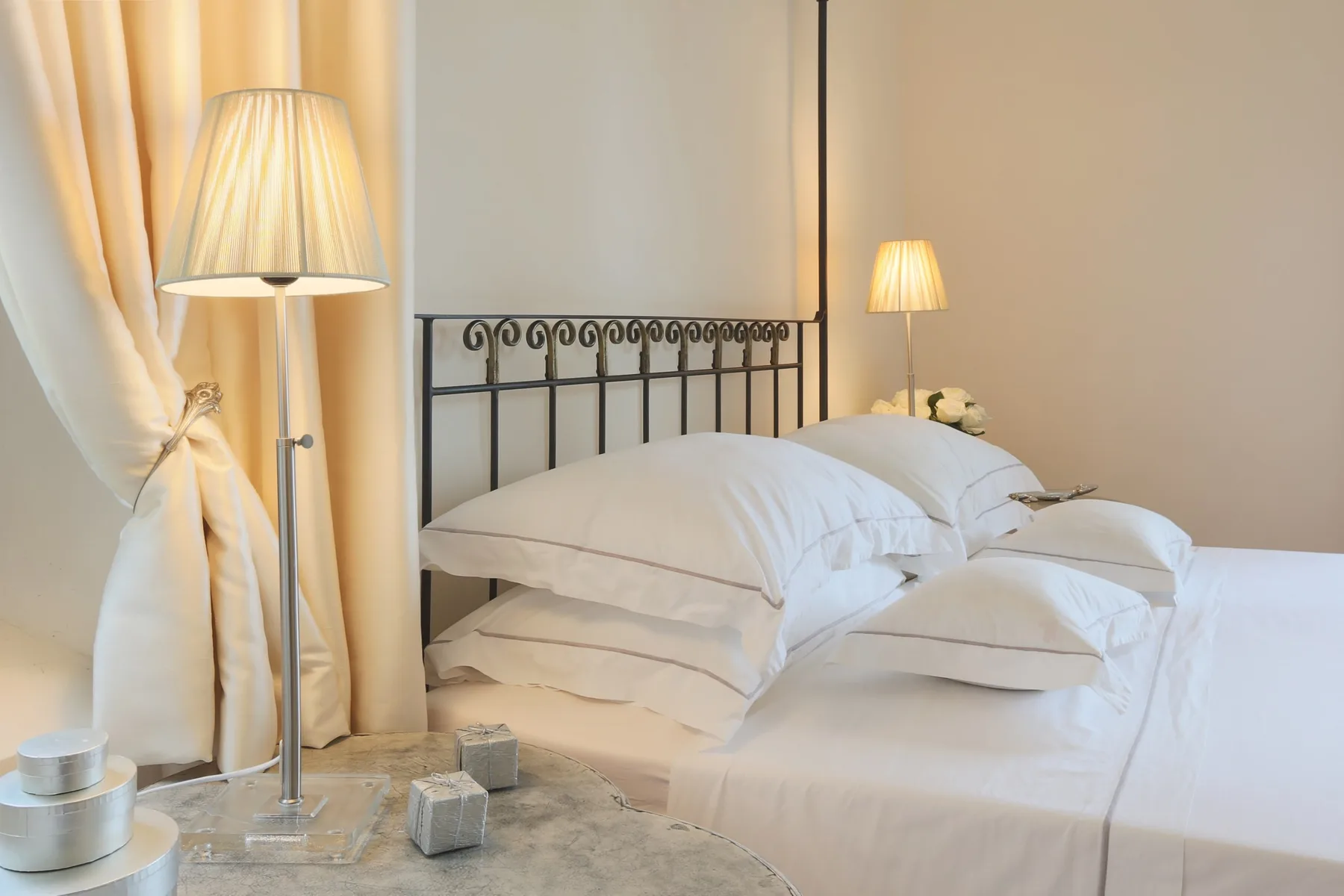 A bedroom with a neatly made bed and bedside lamps.