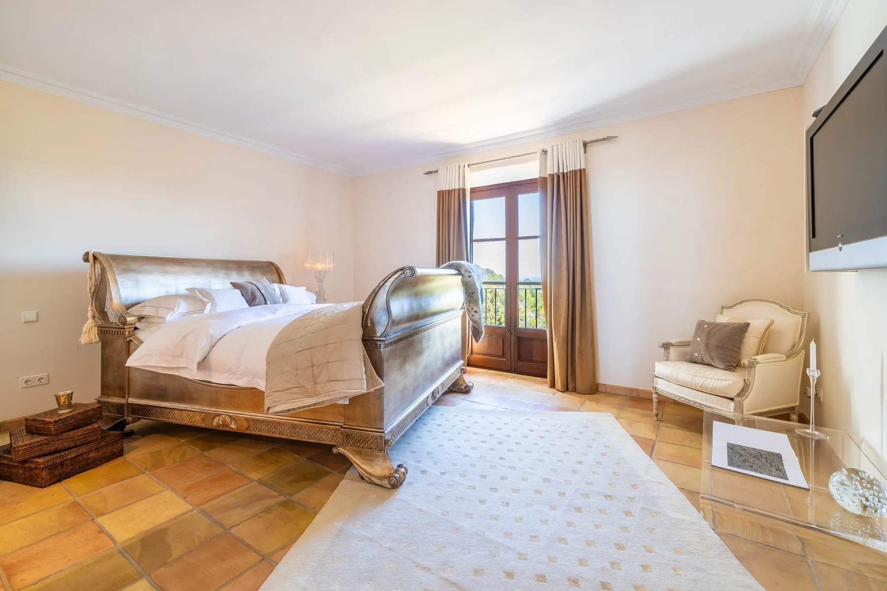 A bedroom with a large bed, a curtained glass door, and a light rug.