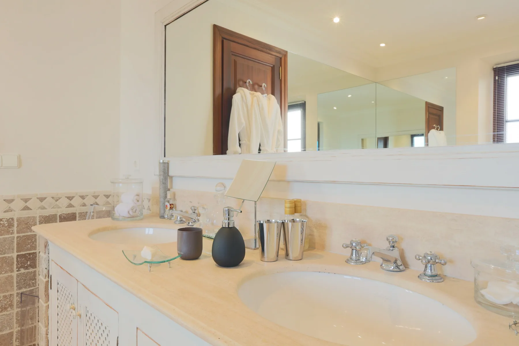 A bathroom vanity with two sinks and a large mirror.