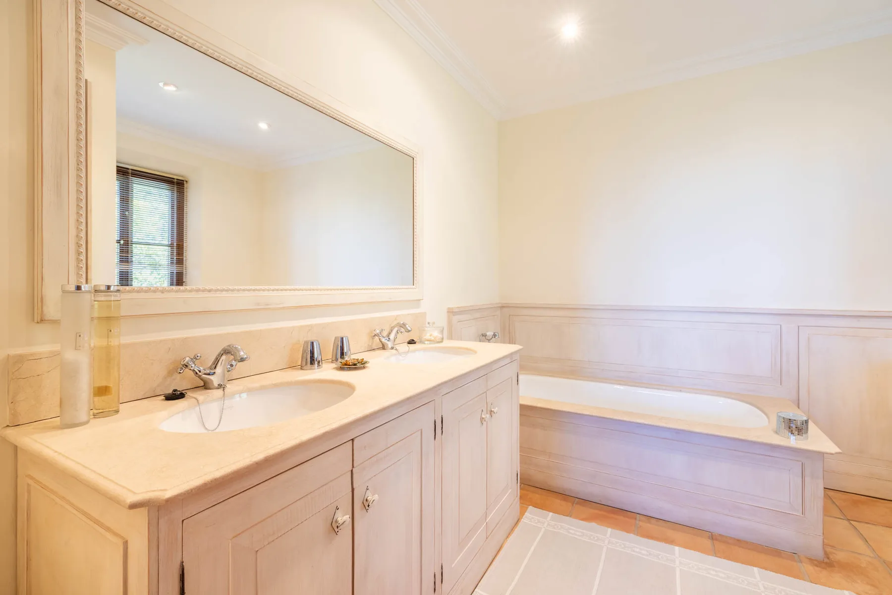 A bright bathroom features a double-sink vanity and a bathtub.