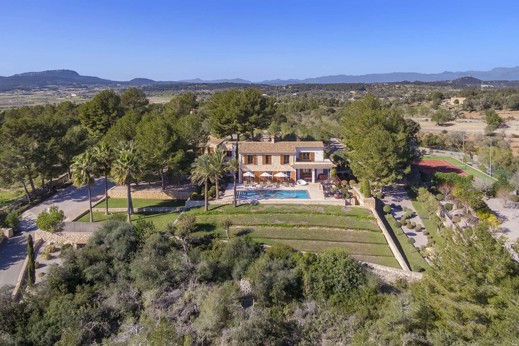 Aerial view of a landscaped property with a house and swimming pool.
