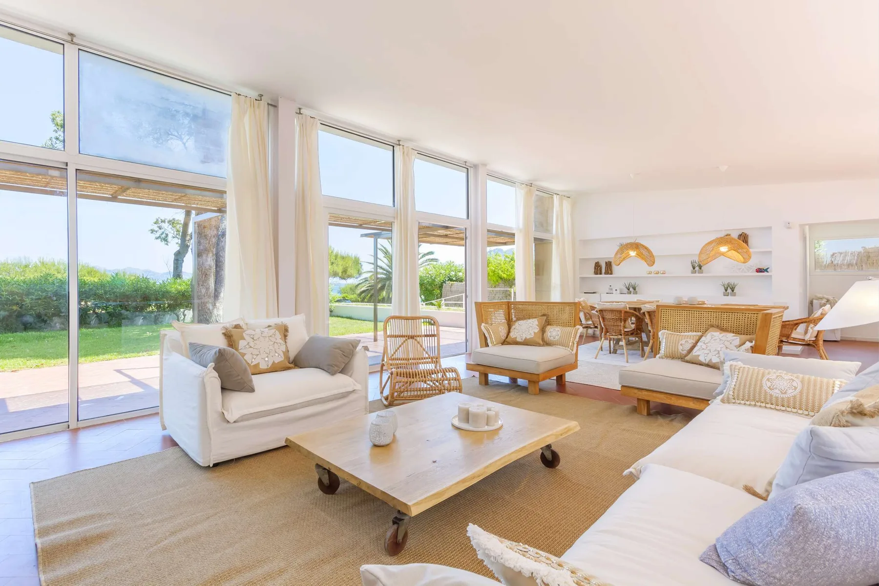A bright living room with seating around a low coffee table and large windows.