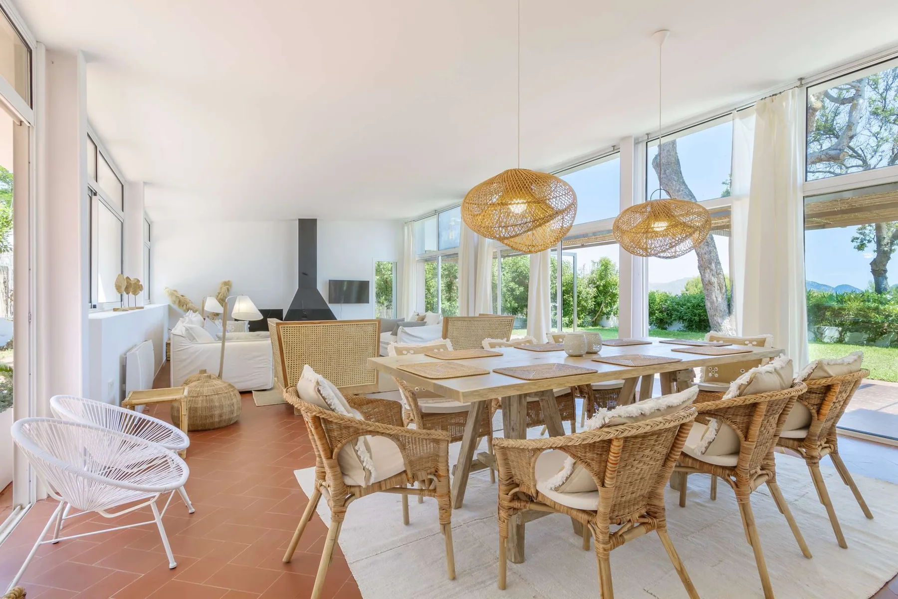 A bright dining area with a long wooden table and large windows.