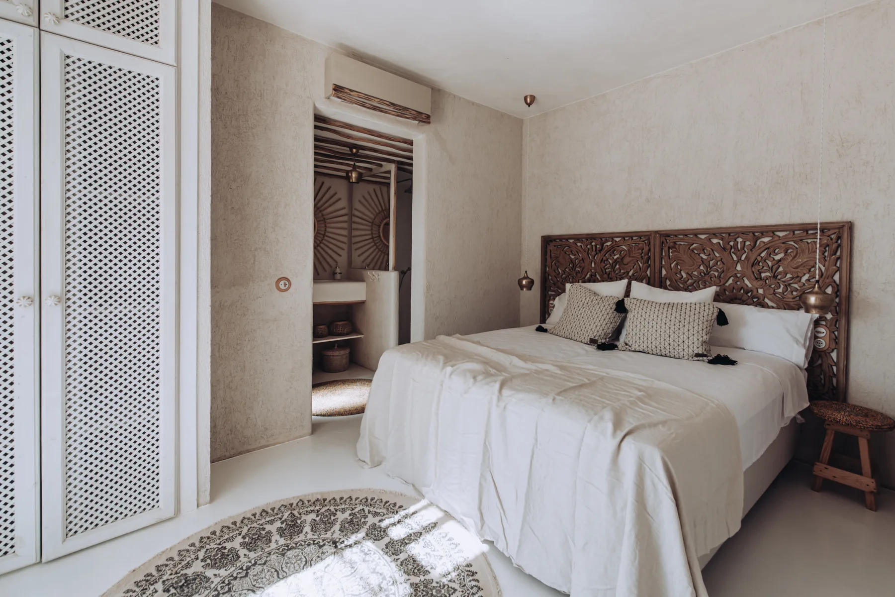 A bedroom with a large bed and an ornate carved headboard.