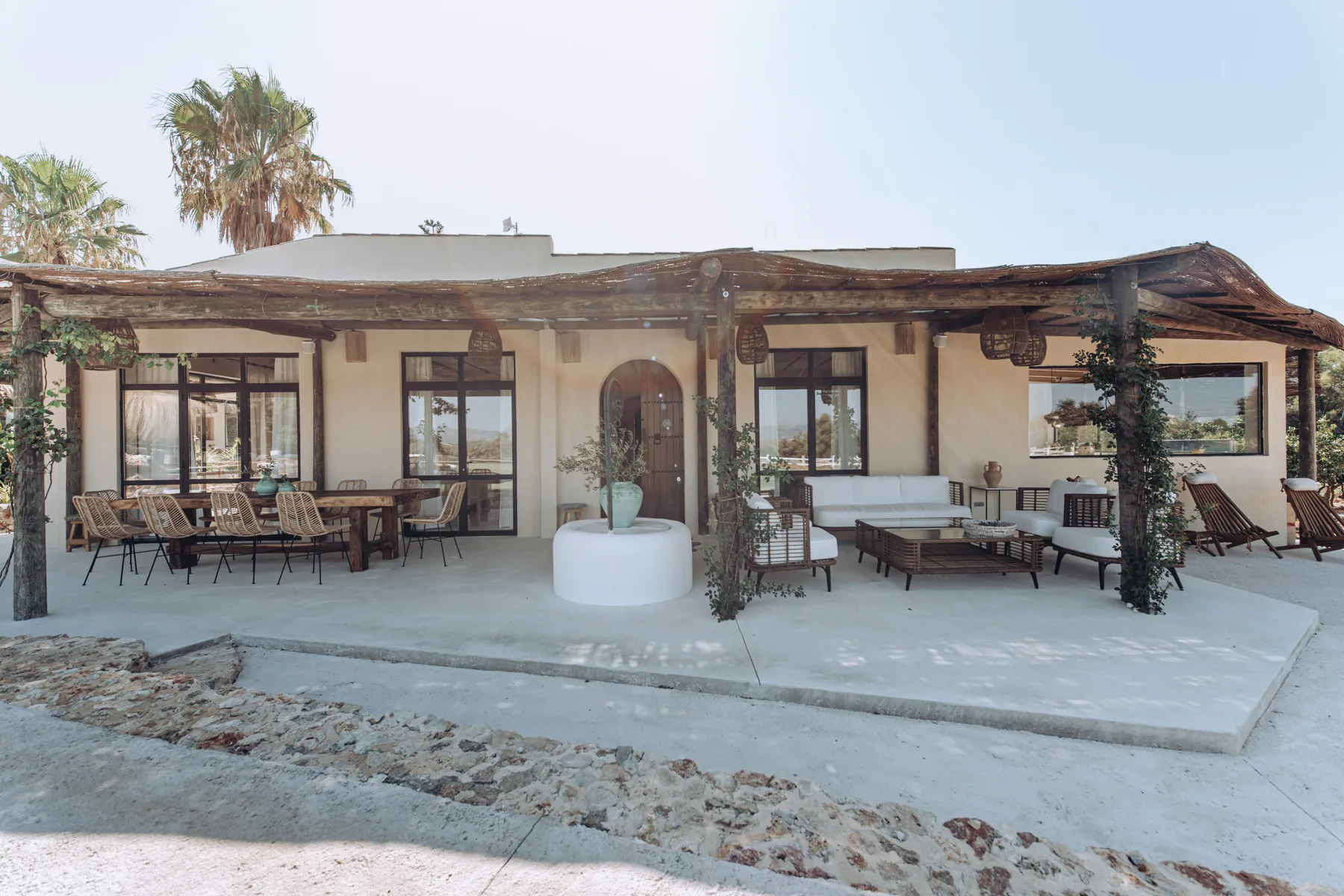 A covered outdoor patio with seating and a low central planter.