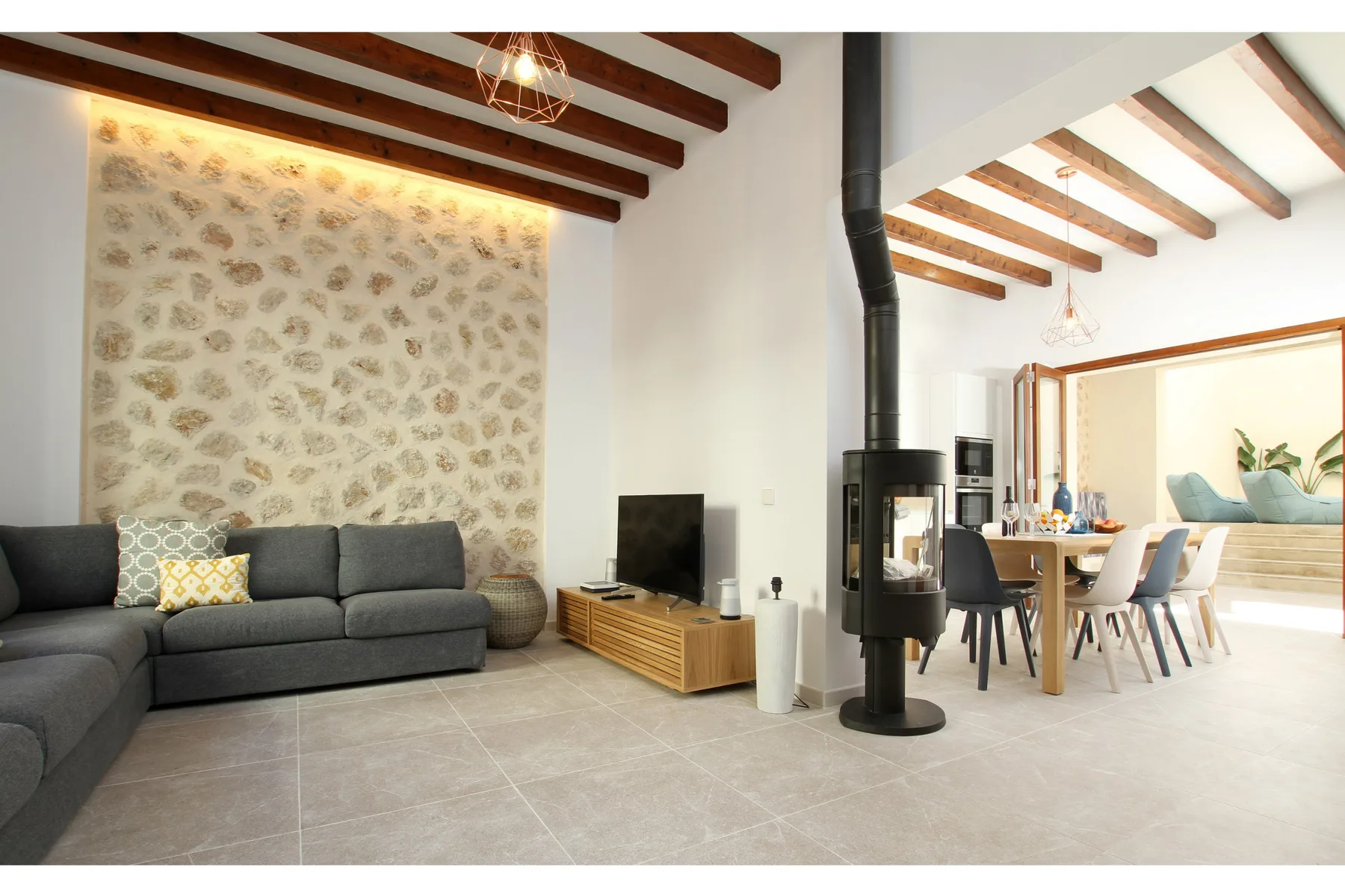 A bright living and dining area with a sectional sofa and dining table.